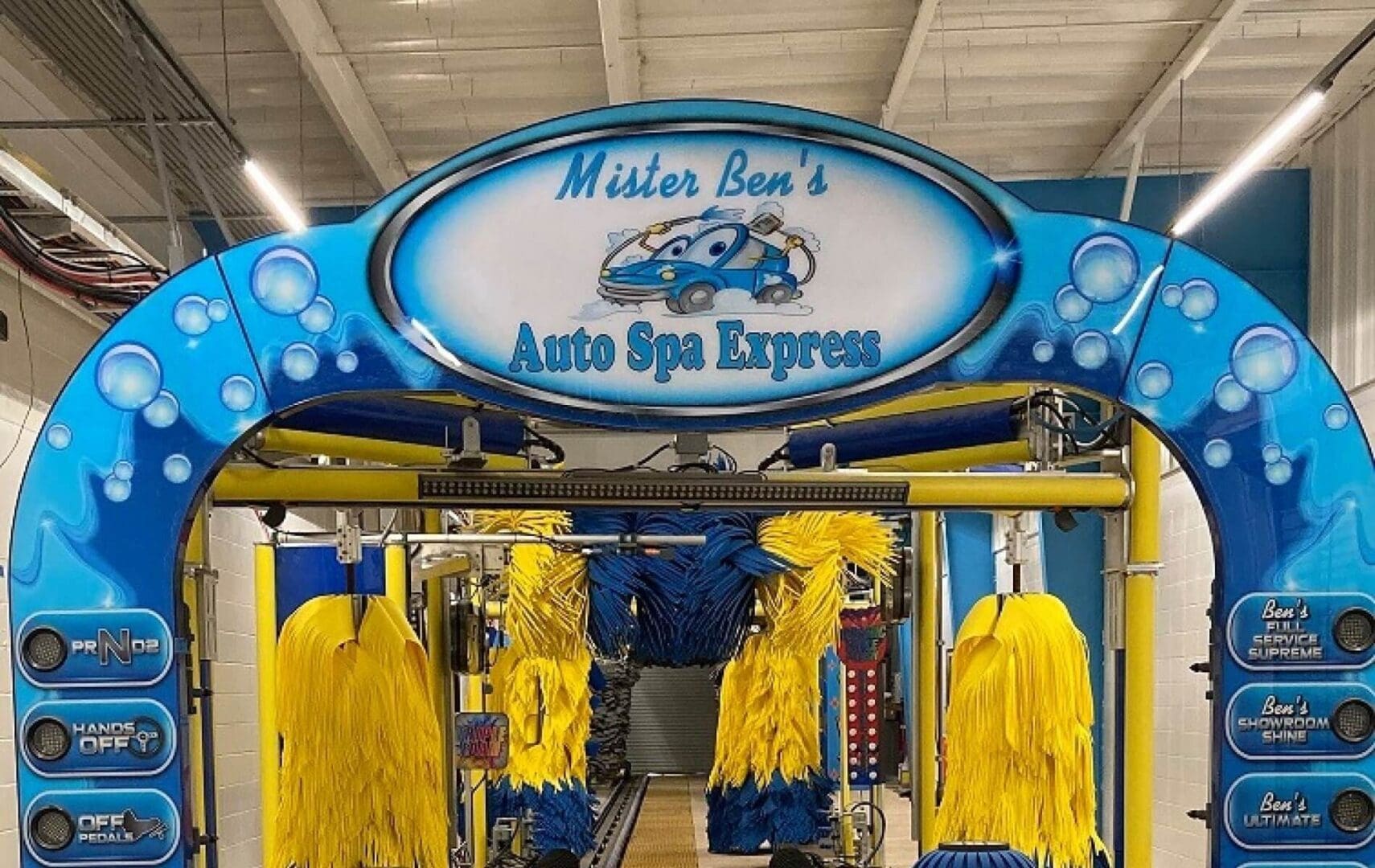 A car wash with yellow gloves hanging from the ceiling.