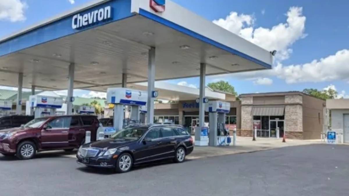 A car parked at the gas station next to a chevron sign.