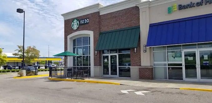 A starbucks with tables and chairs outside of it