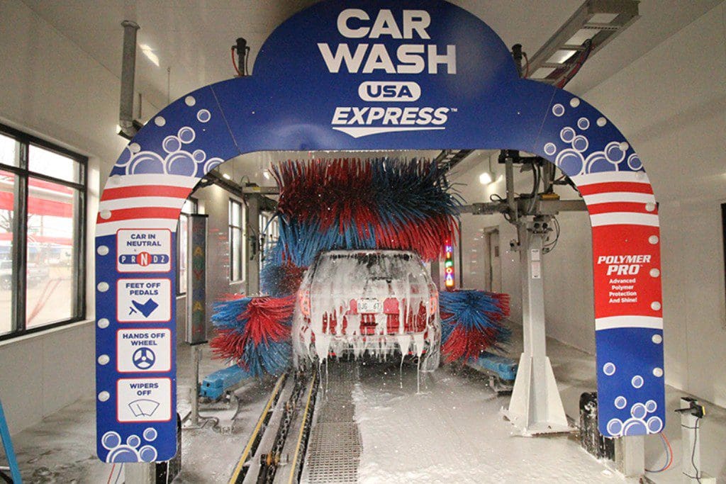 A car wash with a large arch and lots of blue and red colored water.
