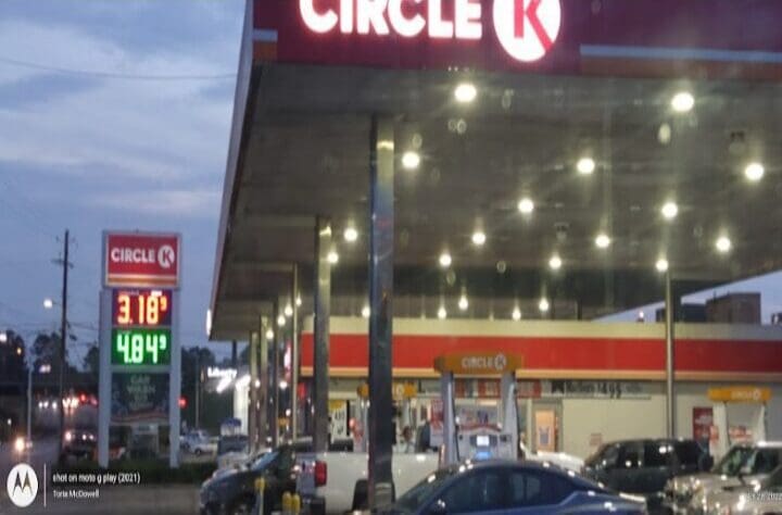 A circle k gas station with cars parked at the curb.