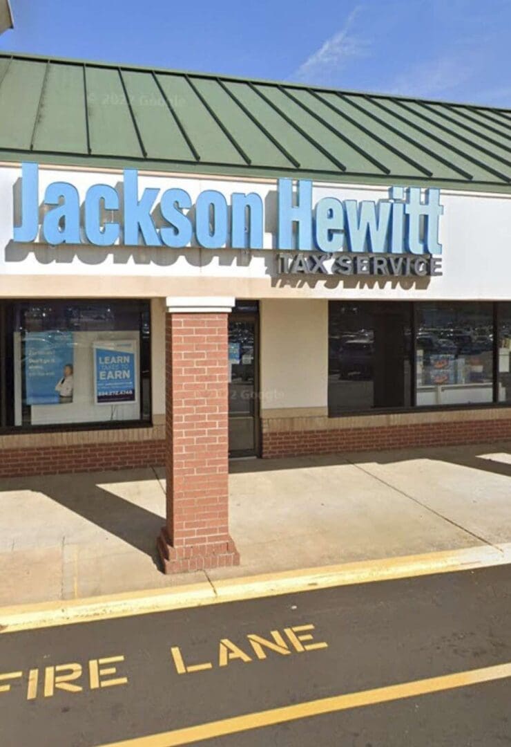 A sign for jackson hewitt tax service on the side of a building.