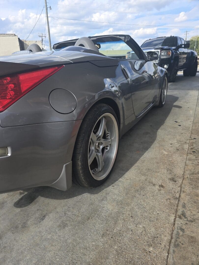 Gray sports car with visible rear wheel and fuel cap.